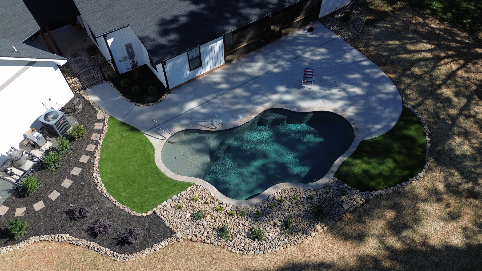 Finished pool with travertine decking and landscaping