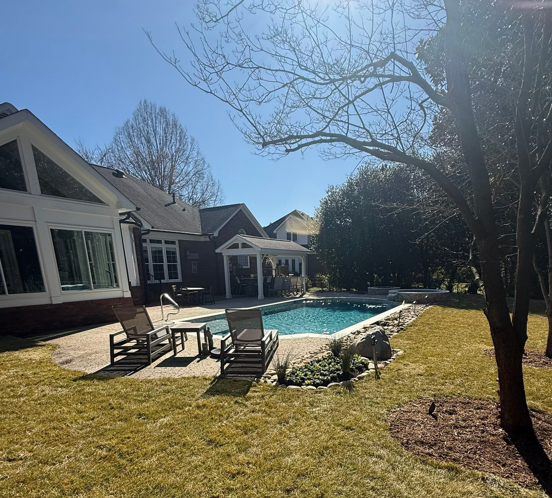 Concrete pool with pergola and lounge chairs